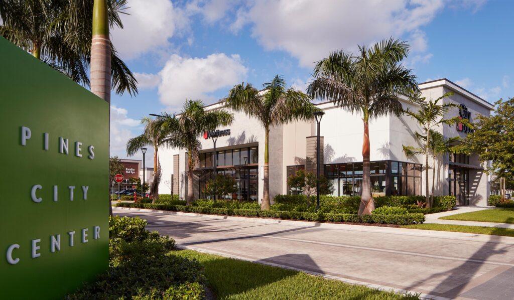 Open-air shopping center exterior at Pembroke Gardens in Pembroke Pines with palm trees