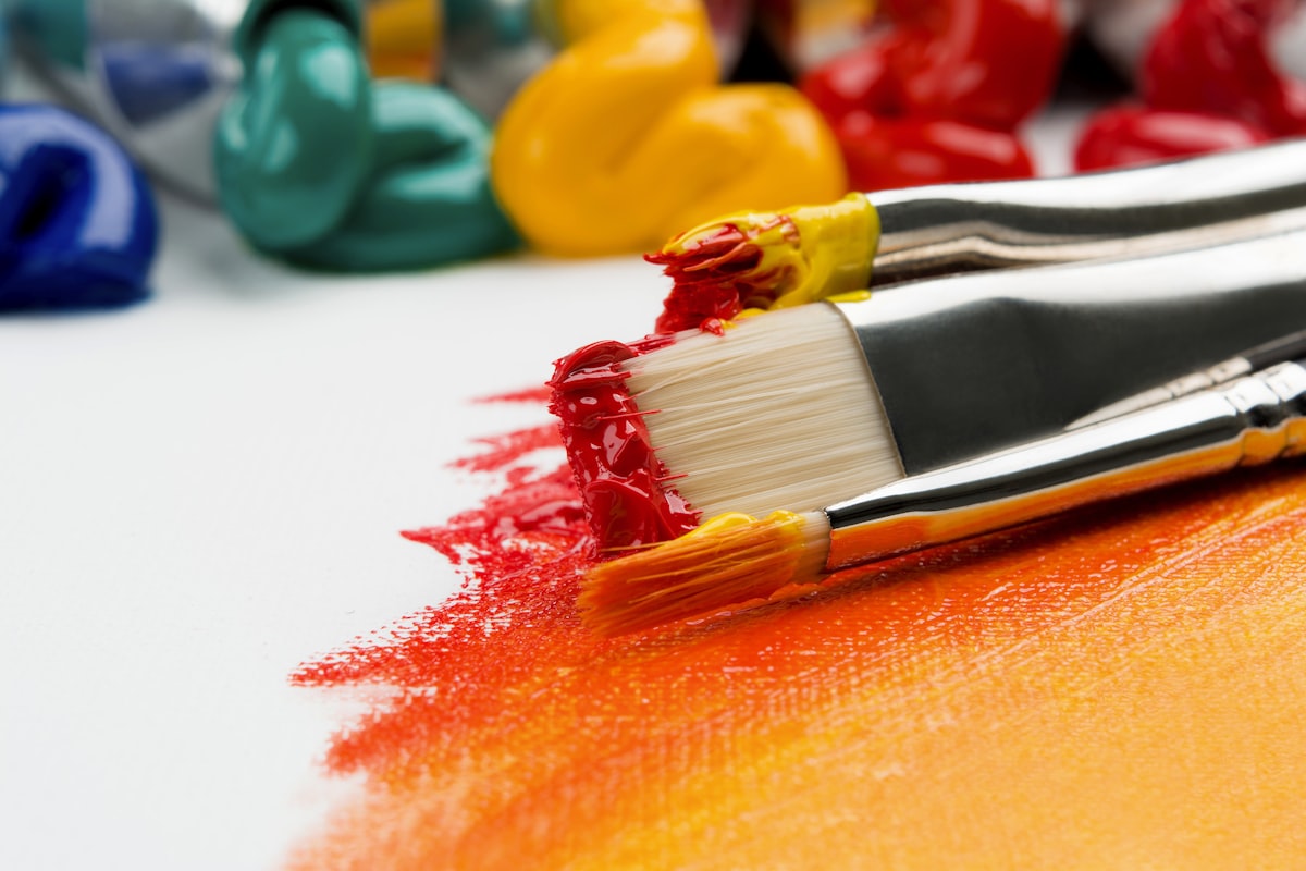 Children painting, sculpting, and working at multiple art stations in a vibrant community studio